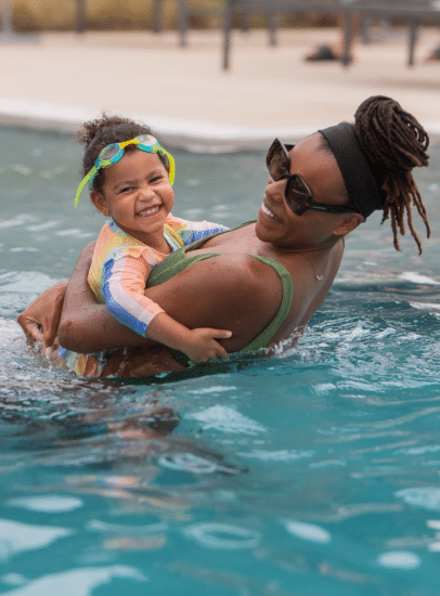 Mother swimming with their child in the pool